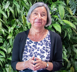 Photo of Fazilet, a woman with brown skin and short greying hair that frames her face and bright smile. 