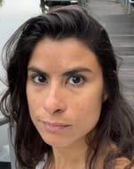 Profile picture of Alessandra, a mixed-race Brazilian woman with dark hair and dark eyes, with an intent gaze.